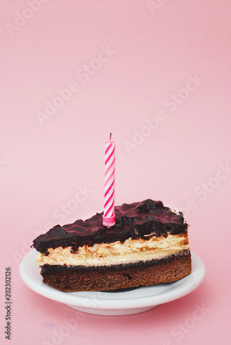 Chocolate Cake on Pink Background with Candle and Copy space. Birthday Party Desert.