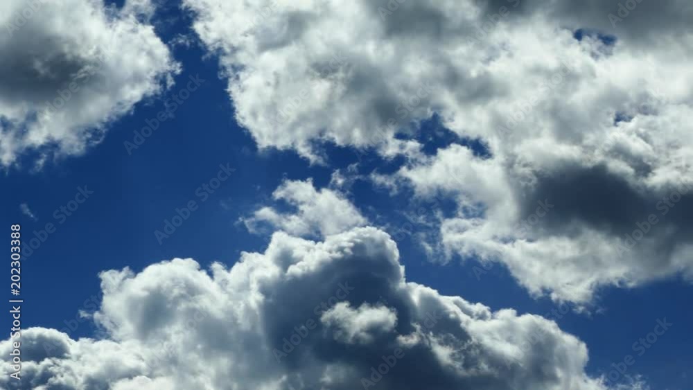 Clouds fly fast over the sky. The white-blue clouds move along the blue sky.