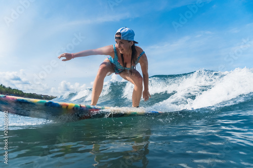 cheerful woman in swimming suit surfing in ocean © LIGHTFIELD STUDIOS