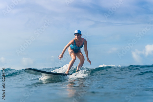 attractive woman in swimming suit surfing in ocean © LIGHTFIELD STUDIOS