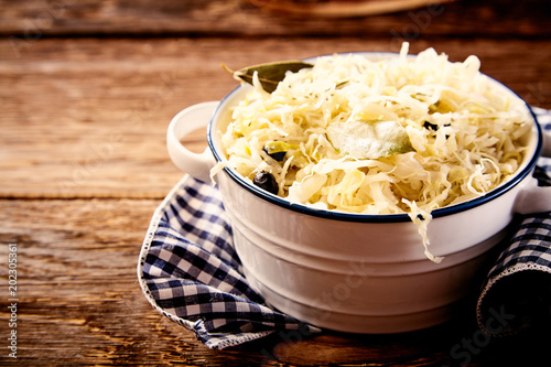 Bowl of sauerkraut in close up on wooden table photo