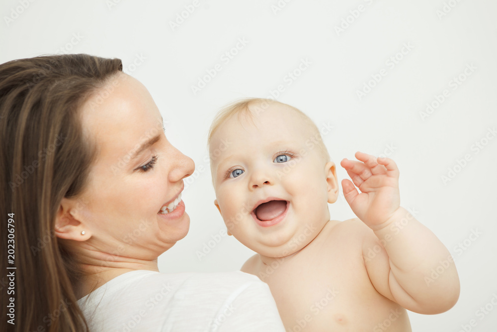 Woman holding on arms her adorable baby toddler, smiling child Woman holding on arms her adorable baby toddler, smiling child