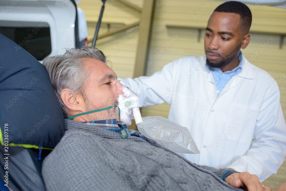 Male patient on stretcher wearing oxygen mask Male patient on stretcher wearing oxygen mask