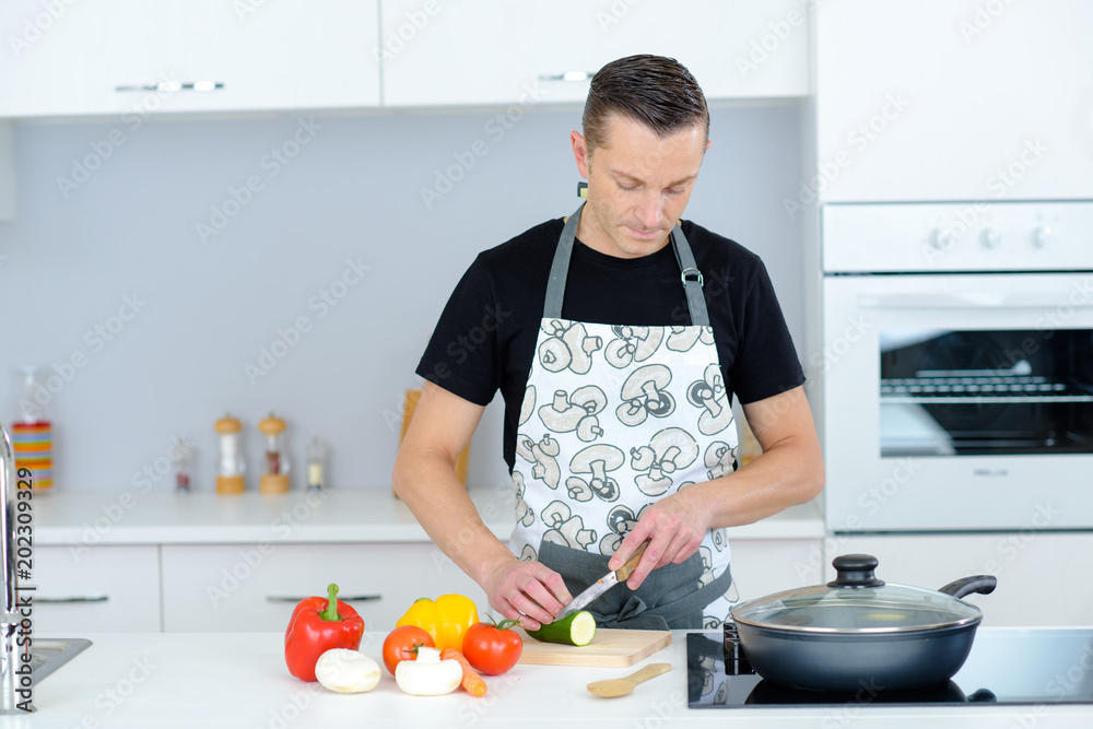 man chopping vegetables in the kitchen