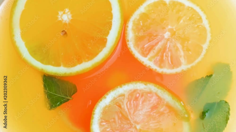 Closeup slow motion video of cold lemonade with oranges, grapefruits and fresh mint leaves Closeup slow motion video of cold lemonade with oranges, grapefruits and fresh mint leaves