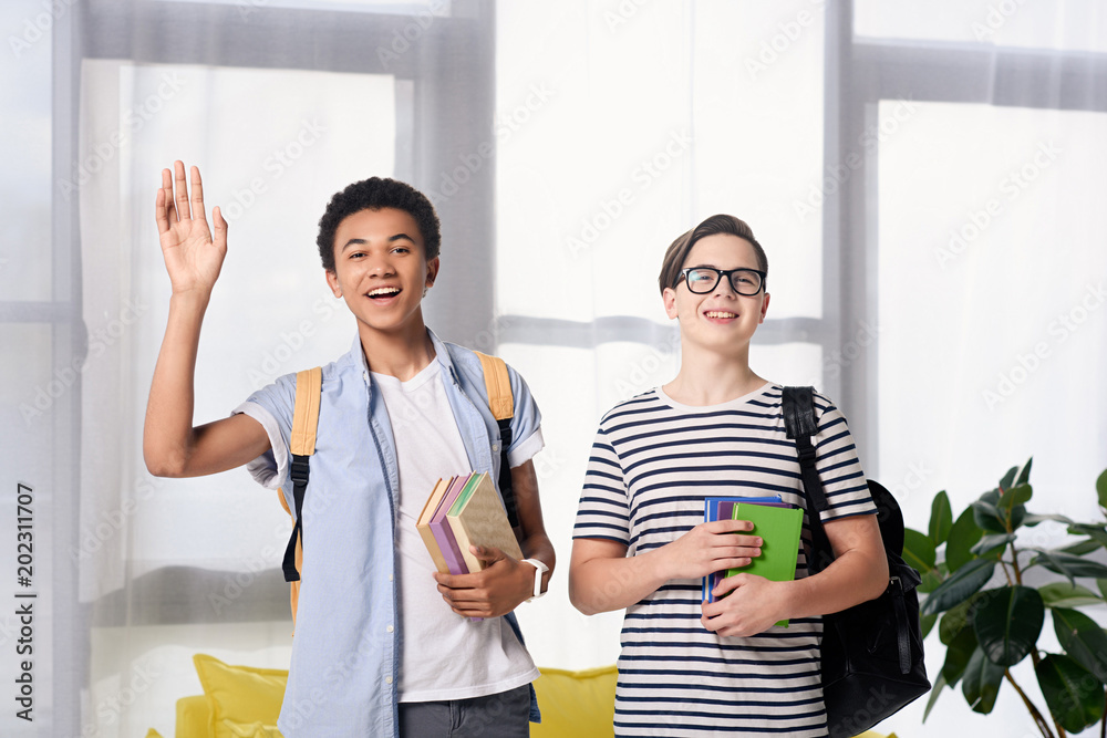 Obraz premium multicultural teen boys greeting someone at home
