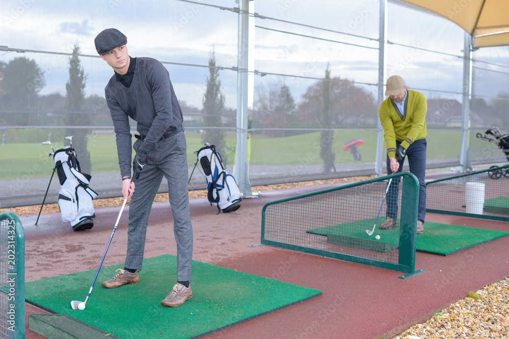 golf players hitting shot with club on course golf players hitting shot with club on course
