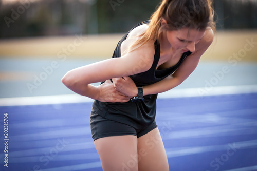 Athlete woman has side crumps  pain during running training