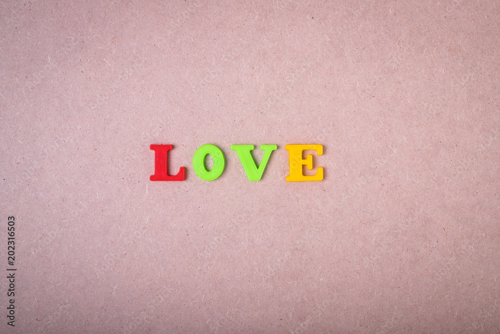 Inscription Love On Brown Wooden Board Background Top View. Inscription Love On Brown Wooden Board Background Top View.