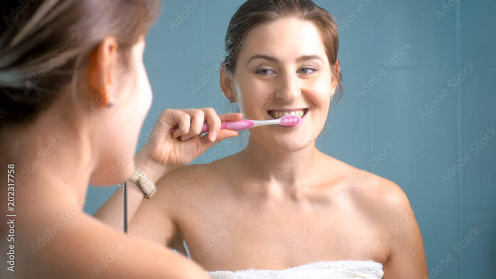 Portrait of beautiful brunette woman cleaning teeth at bathroom Portrait of beautiful brunette woman cleaning teeth at bathroom