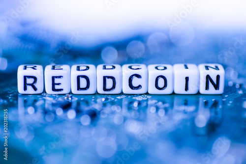 Word REDDCOIN formed by alphabet blocks on mother cryptocurrency photo