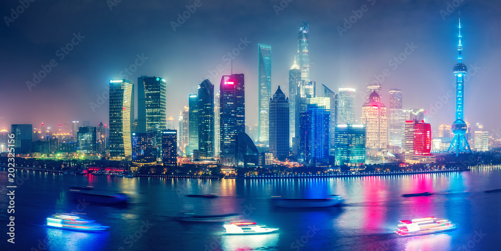 Naklejka premium Widok z lotu ptaka na duże, nowoczesne miasto nocą. Iluminacje miejskie Szanghaju w Chinach. Kolorowa panorama z drapaczami chmur i rzeką Huanpu.