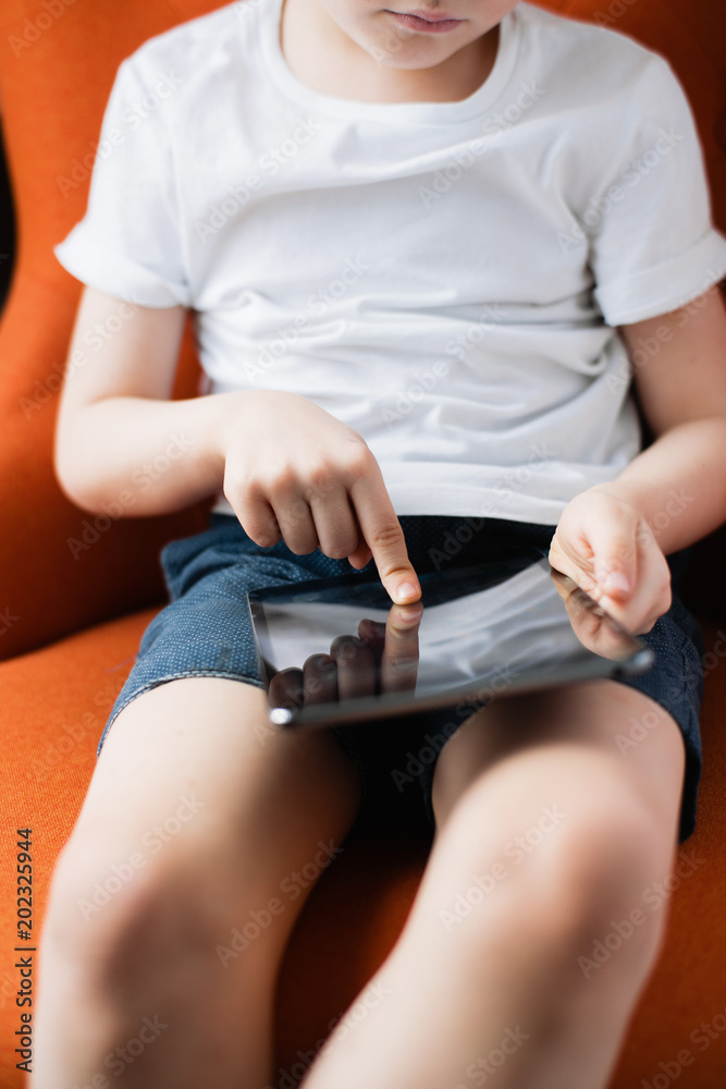 A young boy playing games on his tablet