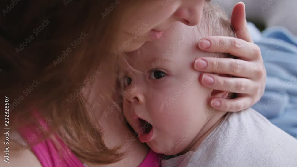 A young mother holding her baby daughter in her arms. Close-up shot A young mother holding her baby daughter in her arms. Close-up shot