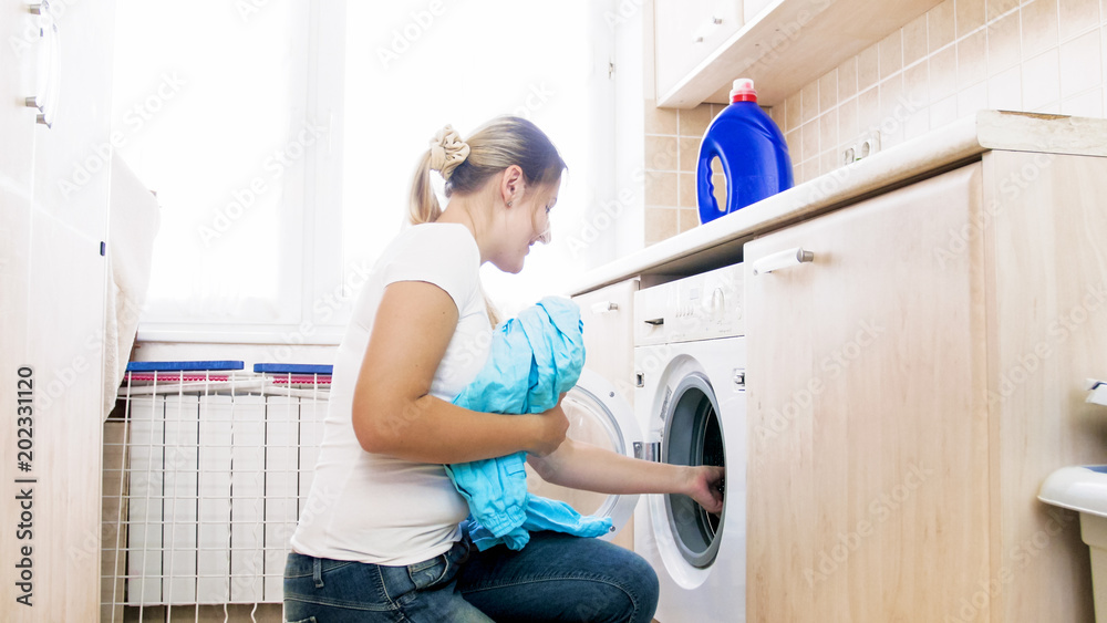 Young woman doing housework in laundry Young woman doing housework in laundry