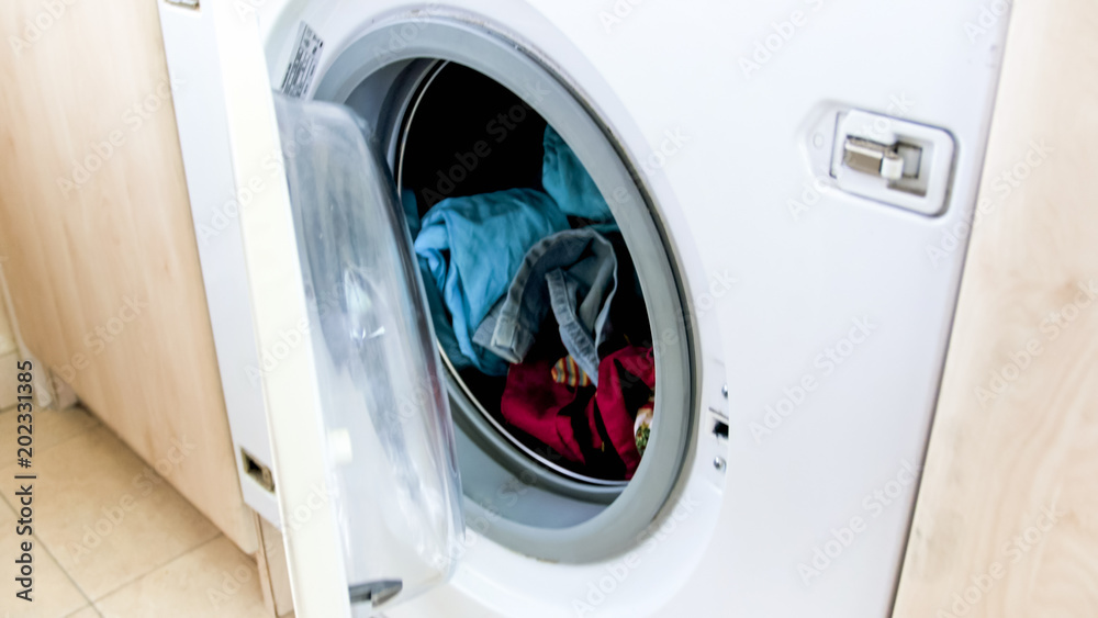 Closeup image of full washing machine with open glass door Closeup image of full washing machine with open glass door