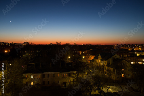 Beautiful Landscape With Residential Buildings, With Light From Street Lamps And Lamps In Houses On Red-Blue Background Of Evening Sky In Spring In City Of Kolomna, Russia.