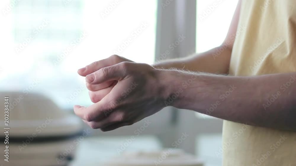 Male hands crumpling a sheet of white paper. Closeup Male hands crumpling a sheet of white paper. Closeup