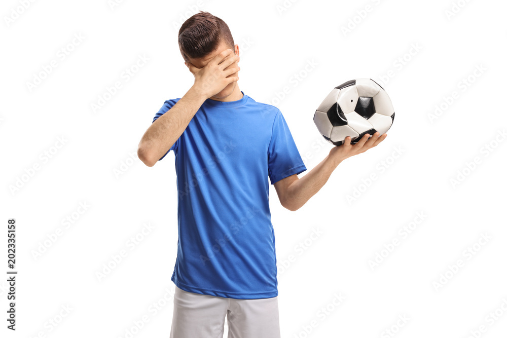Φωτογραφία Teenage soccer player with a deflated football holding his head in disbelief