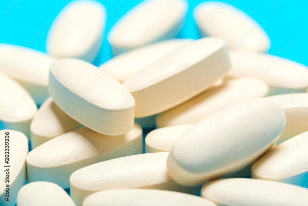 Pills are scattered over a blue background Pills are scattered over a blue background