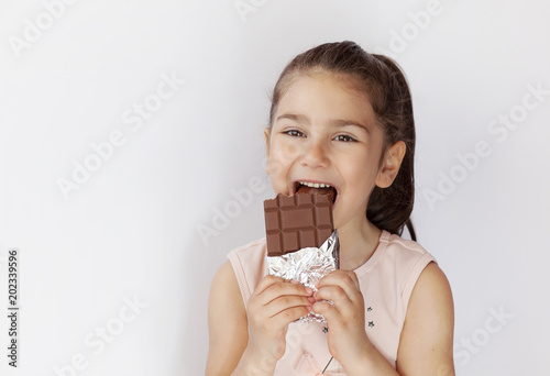 Cute child girl eating chocolate. Pretty child with chocolate.