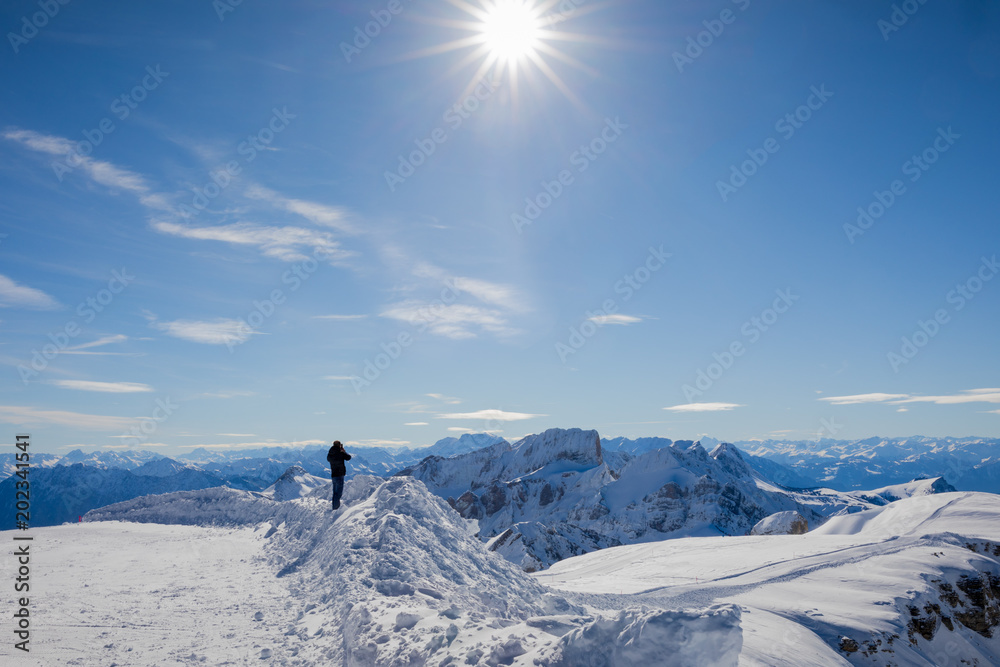 Man looking at the beautiful Winter Panorama in the Swiss Alps
