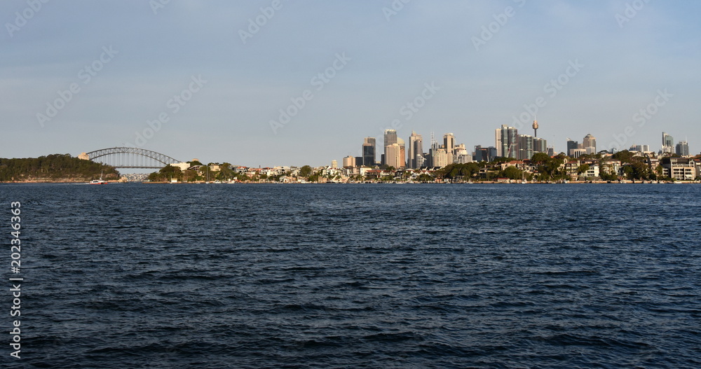 View of Sydney skyline (Harbour bridge, Sydney Tower and skyscrapers) in daytime from Woolwich NSW Australia.