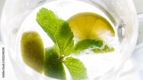 View from above on glass of cold water with mint and lemon