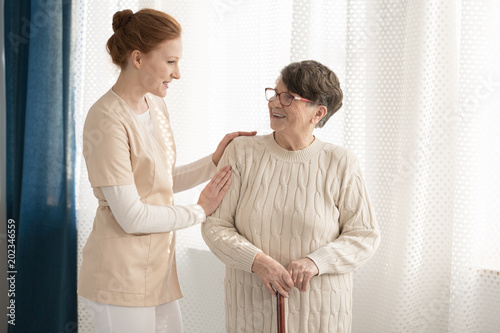 Professional caregiver assisting elderly woman © Photographee.eu