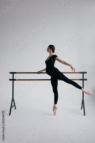 Young beautiful ballerina is posing in studio