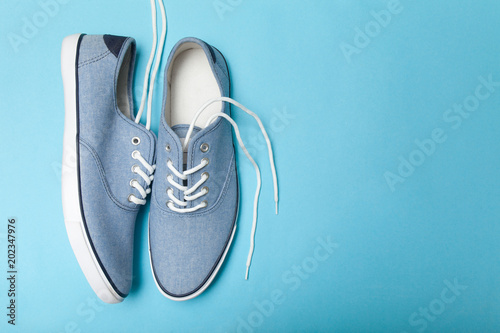 Soft summer comfortable blue sneakers on a blue background. Copy space for text.