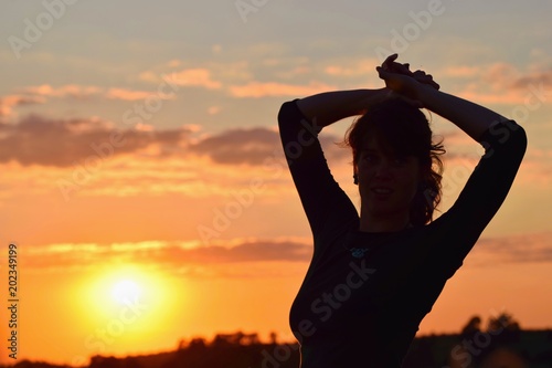 Young woman in sunset light, success, happiness, fitness concept