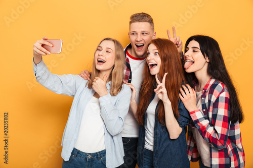 Group of joyful school friends taking a selfie