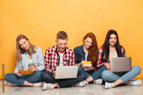 Group of happy school friends doing homework