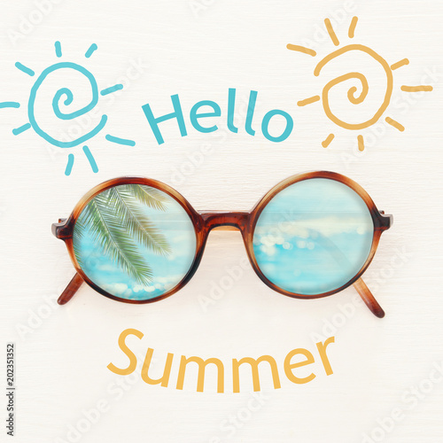 vacation and summer image with sunglasse over white wooden background.