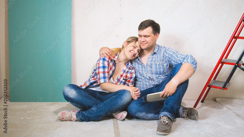 Happy young man and woman hugging in their new haouse under construction