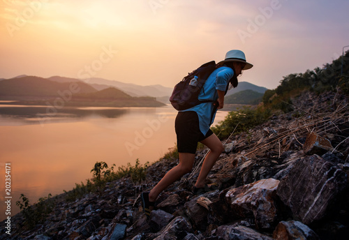 Fotografija Beautiful female tourists are walking up a rocky hill above the lake