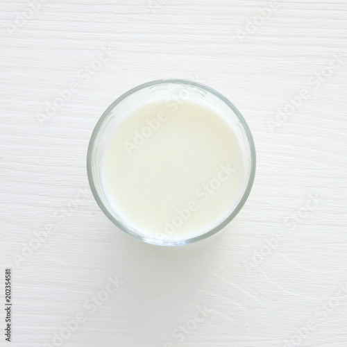 Top view image of milk over white wooden background. Symbols of jewish holiday - Shavuot.