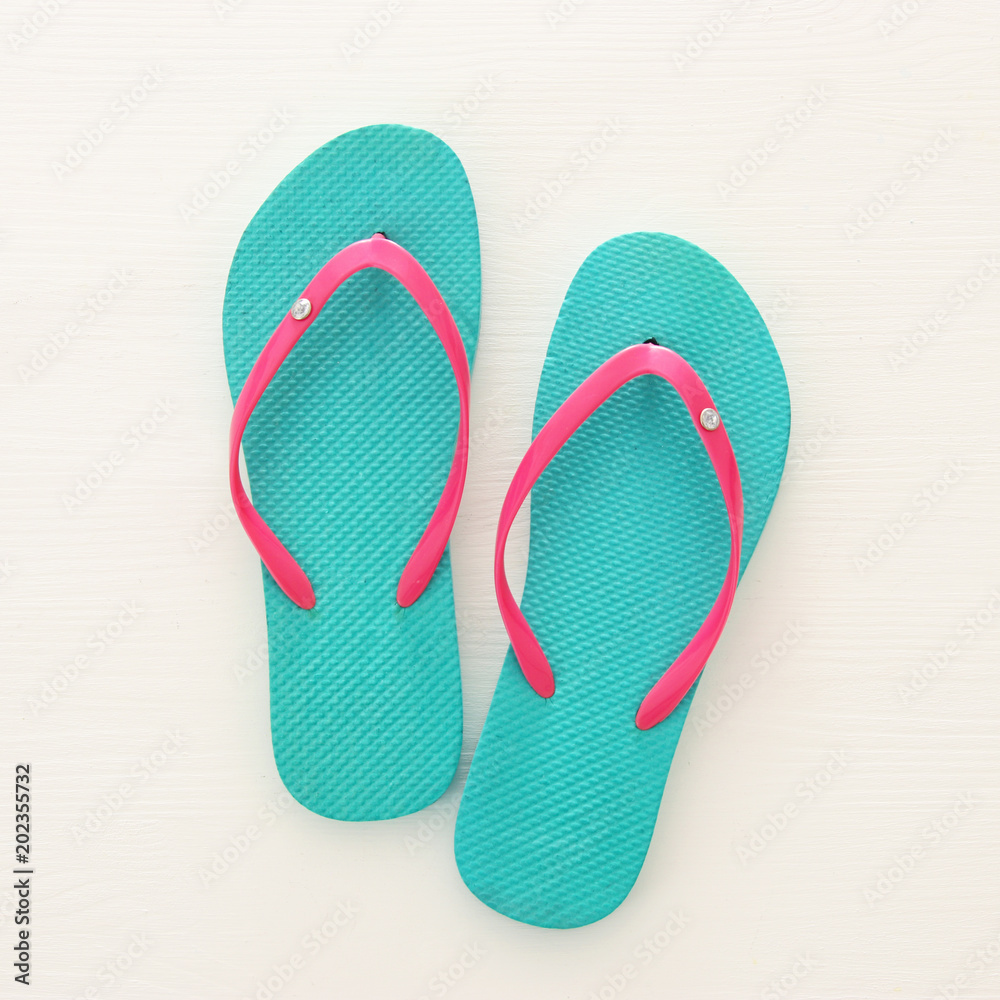 vacation and summer image with flipflops over white wooden background. vacation and summer image with flipflops over white wooden background.