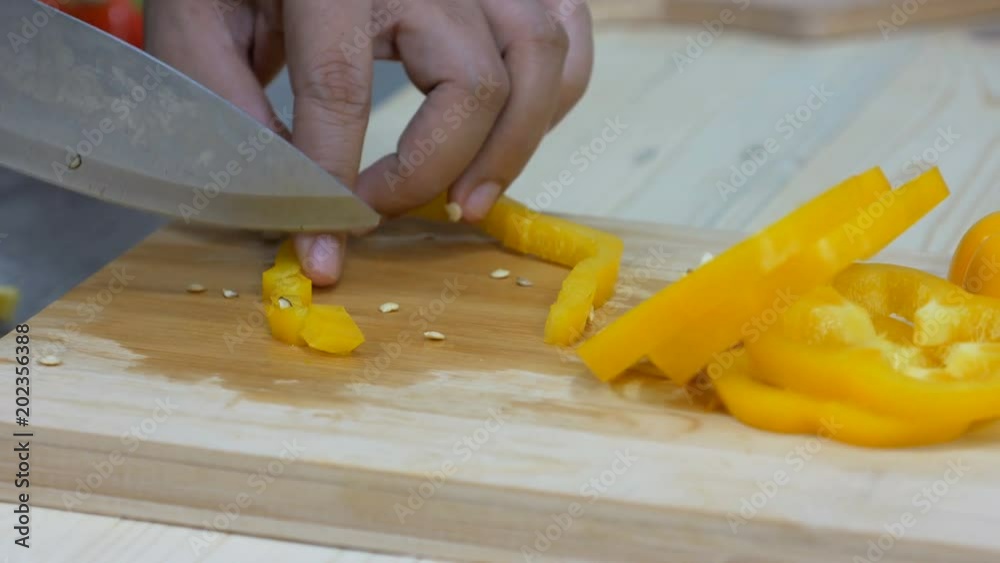 Close up shot Hands of woman using kitchen knife slice and cut the bell pepper vegetable preparing for cooking a food Close up shot Hands of woman using kitchen knife slice and cut the bell pepper vegetable preparing for cooking a food