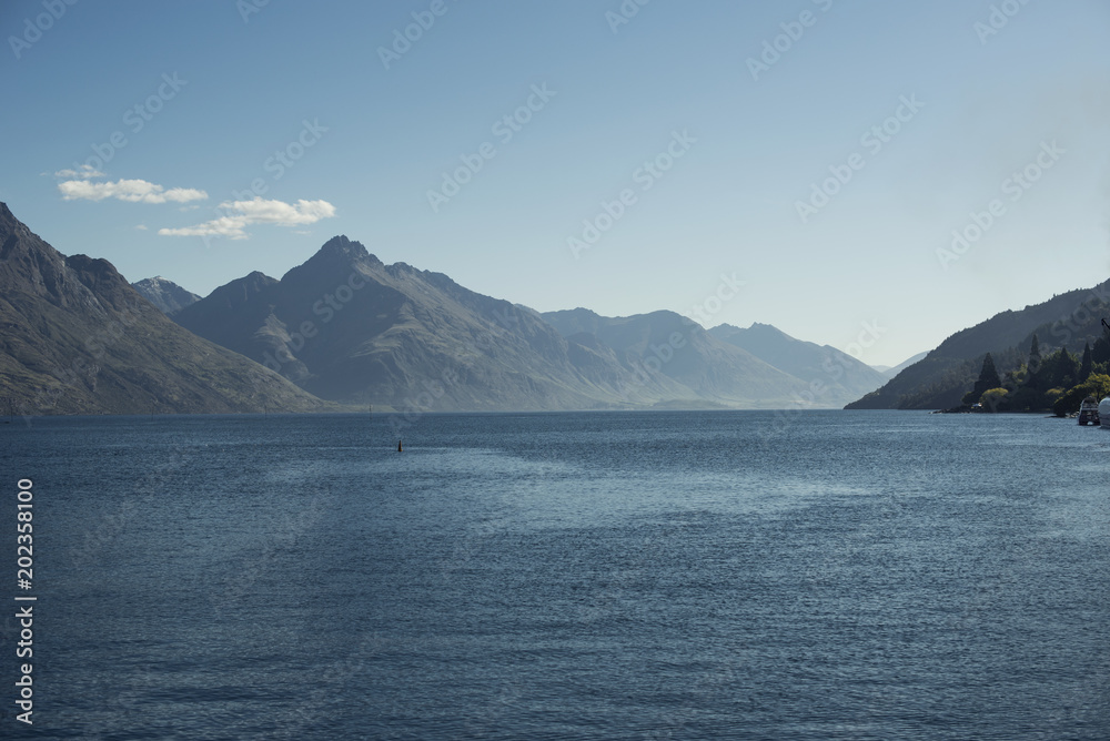 Paisaje de montañas frente a un lago. Escena diurna, cielo azul y despejado. Nueva Zelanda.