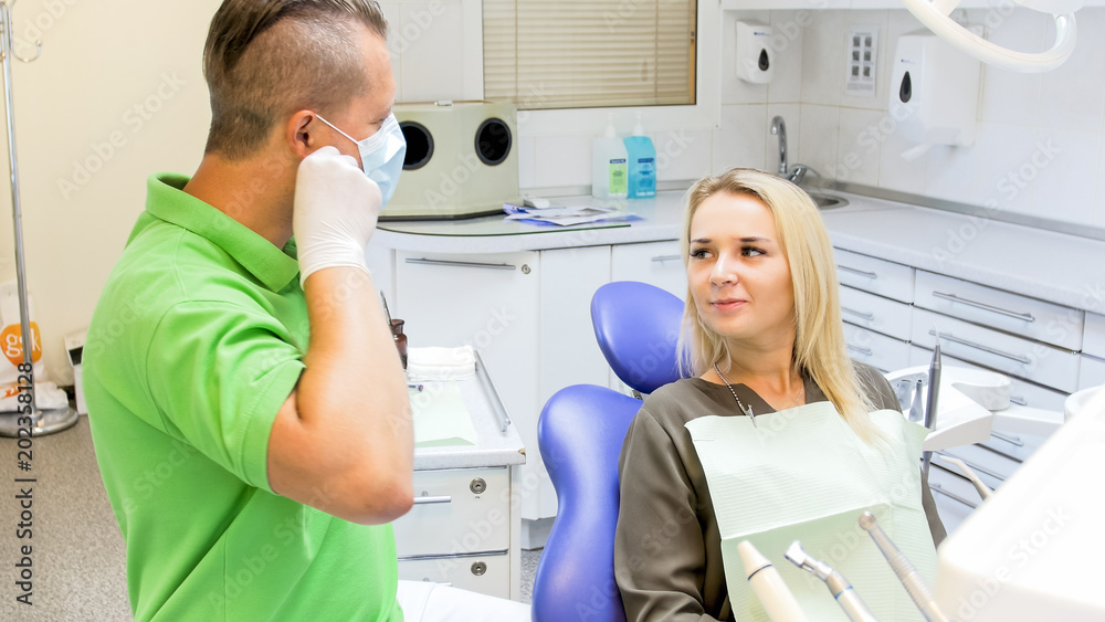Obraz premium Male dentist taking off protective mask after teeth treatment