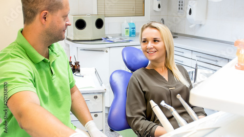 Portrait of beautiful smiling blonde woman visiting dentist office