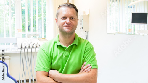 Portrait of male dentist with hands crossed looking in camera