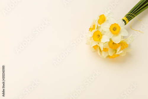 Fototapeta Naklejka Na Ścianę i Meble -  White daffodil bouquet on yellow pastel background with copy space.
