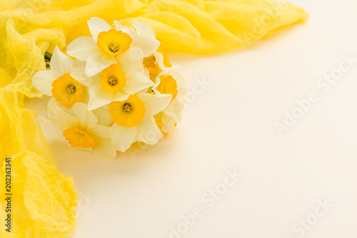 Fototapeta Naklejka Na Ścianę i Meble -  White daffodil bouquet with yellow textile decoration on pastel background with copy space.