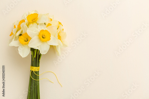 Fototapeta Naklejka Na Ścianę i Meble -  White daffodil bouquet on yellow pastel background with copy space.