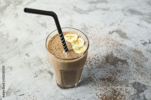 Chocolate-banana smoothies with cocoa in a glass on a gray background. Healthy food concept photo