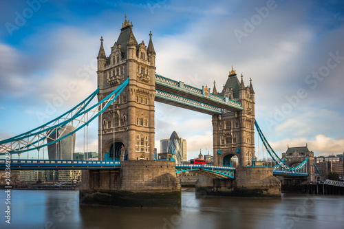 London  England - Iconic Tower Bridge with traditional red double-decker bus and skyscrapers of Bank District at background