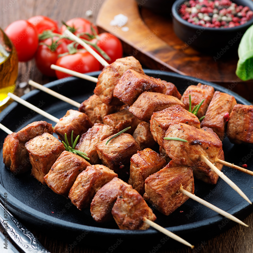 Barbecue meat. Grilled pork skewers on wooden table.